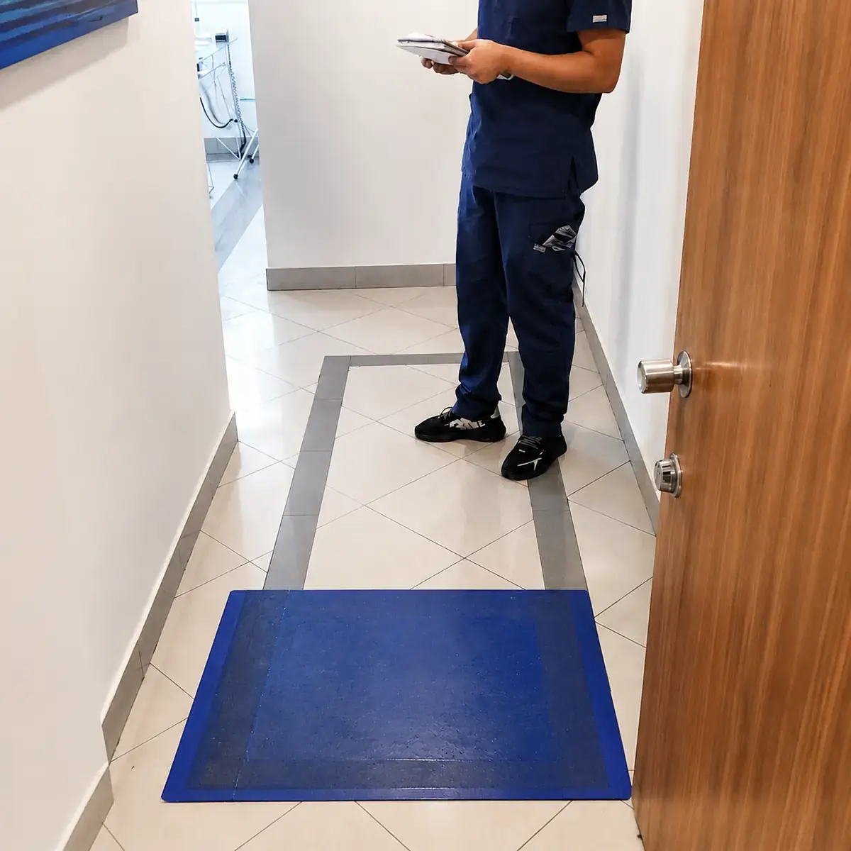 Sticky Mat azul instalado en el acceso interior de una clínica odontológica